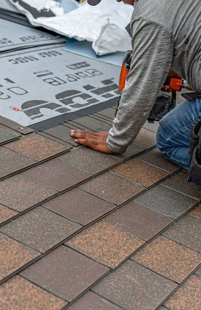 Skilled roofer installing asphalt shingles, ensuring quality home renovation.